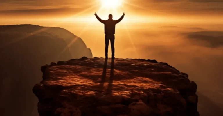 Man looking at the sun on a rock